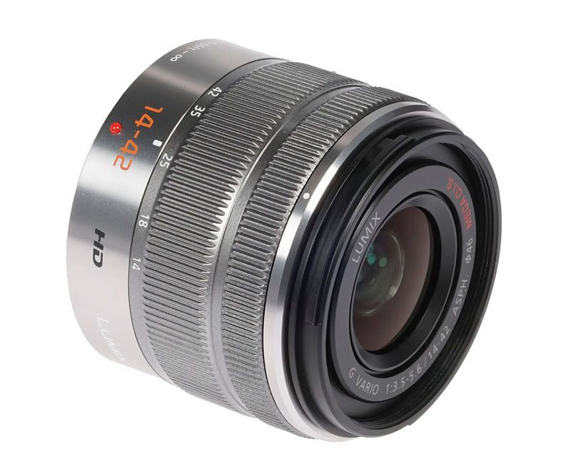 Объектив Panasonic Lumix G Vario 14-42mm f/3.5-5.6 серебристого цвета на белом фоне